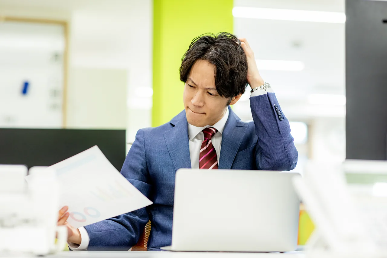 資料を見比べながら予算に頭を悩ませる店舗オーナー