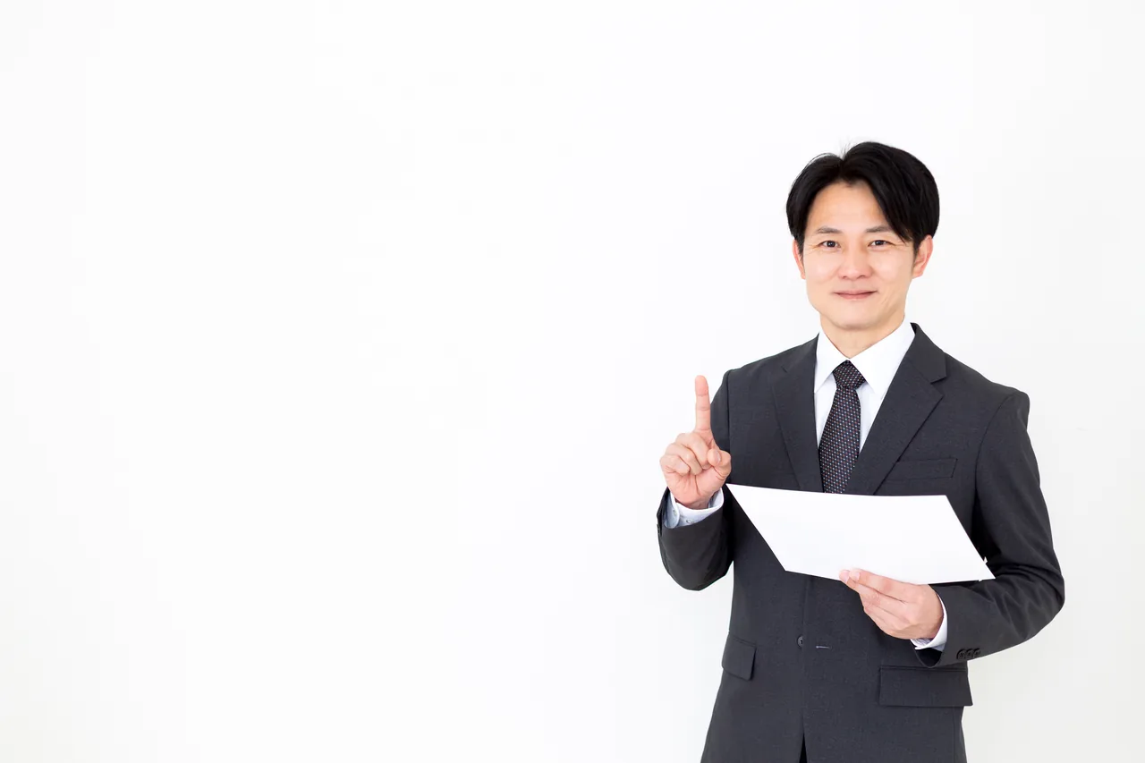資料を手に見直しのポイントを説明する担当者